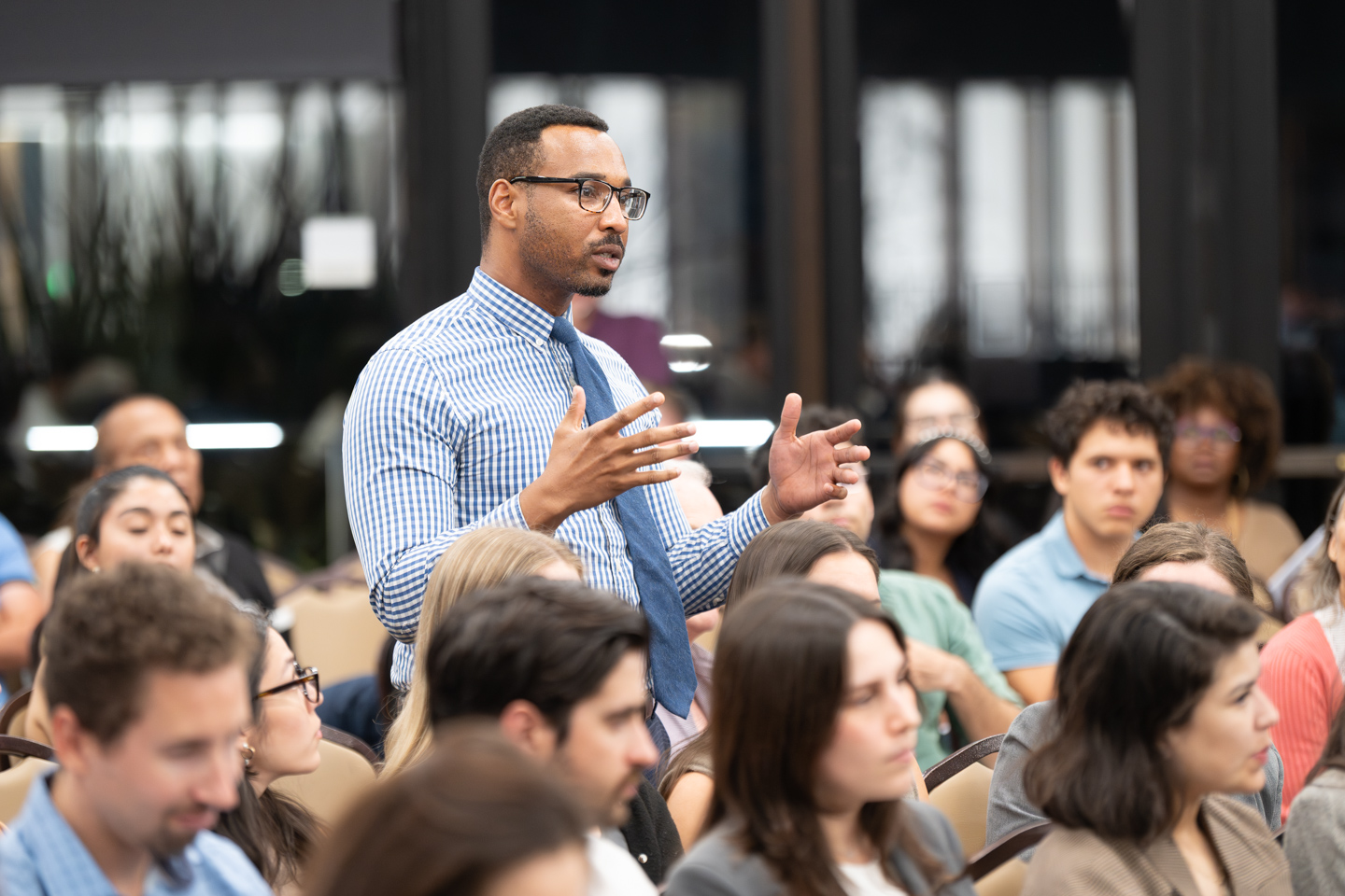 A student standing to ask a question during a Forum session